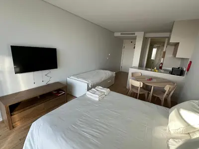 a hotel room with a bed and a tv at New Douro Tower 203 With Parking in Vila Nova de Gaia
