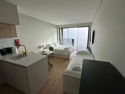 a kitchen and living room with a bed and a sink at New Douro Tower 305 with shared pool and parking in Vila Nova de Gaia