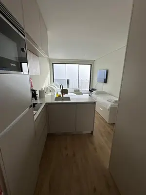 a kitchen with a sink and a refrigerator in a room at New Douro Tower 305 with shared pool and parking in Vila Nova de Gaia