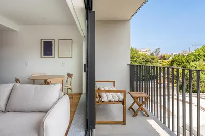 a living room with a couch and a table on a balcony at Spacious Studio Apartment in Porto