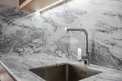 a marble kitchen with a sink and a faucet at Spacious Studio Apartment in Porto