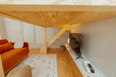 a living room with a couch and a tv at Deluxe Studio by Hosty in Porto