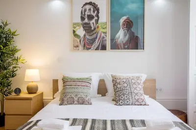 a bedroom with a bed with two pictures on the wall at Porto Pacific - Almeida Garrett - estúdio a 5 minutos da Ribeira in Porto