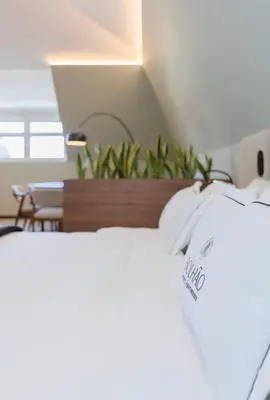 a bedroom with two white beds and a table at Bolhão Luxury Apartments in Porto