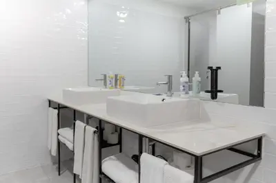 a white bathroom with two sinks and a mirror at Magnolia - Exclusive Garden Apartment in Porto