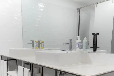 a white bathroom with two sinks and a mirror at Magnolia - Exclusive Garden Apartment in Porto