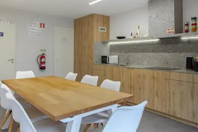 a kitchen with a wooden table and white chairs at Magnolia - Exclusive Garden Apartment in Porto