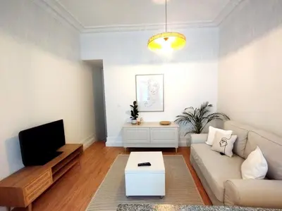 a living room with a couch and a tv at Elegant duplex, WiFi, Porto center in Porto