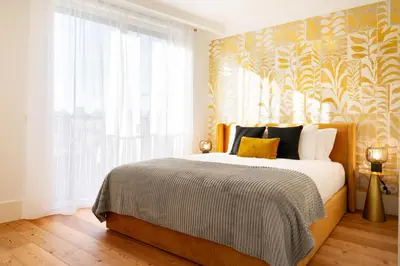 a bedroom with a bed and a large window at Bonjardim Signature Apartment 4B in Porto