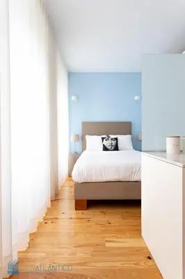 a bedroom with a white bed with a cat on it at Blu Constellation - Santa Catarina in Porto