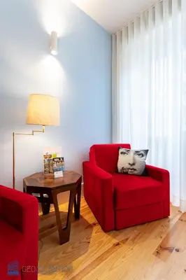 a living room with a red chair and a table at Blu Constellation - Santa Catarina in Porto