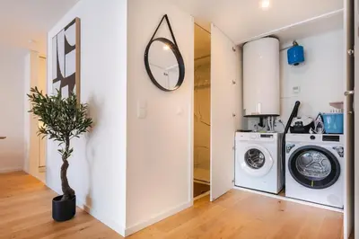 a laundry room with a washing machine and a mirror at Aires Ornelas Gem, City Escape with Private Parking in Porto
