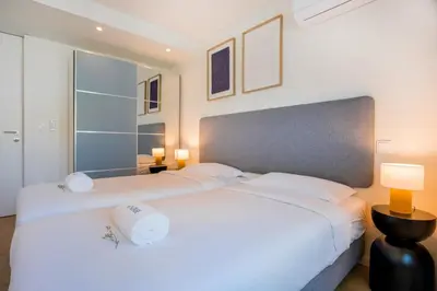 a bedroom with a large white bed and two lamps at Aires Ornelas Gem, City Escape with Private Parking in Porto