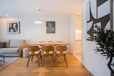 a dining room and living room with a table and chairs at Aires Ornelas Gem, City Escape with Private Parking in Porto