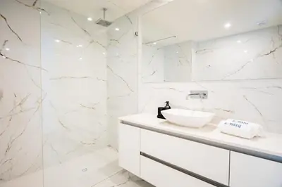 a white bathroom with a sink and a shower at Aires Ornelas Gem, City Escape with Private Parking in Porto