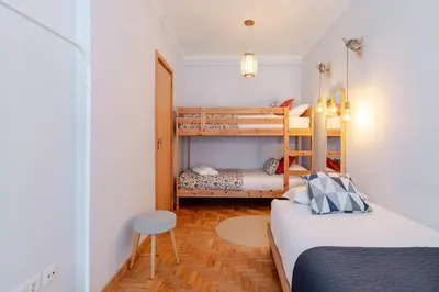a small bedroom with two bunk beds and a stool at Light-Filled Cedofeita Apt by HostWise in Porto