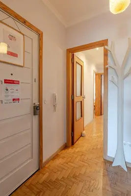 a hallway with a white door and a cross on the wall at Light-Filled Cedofeita Apt by HostWise in Porto