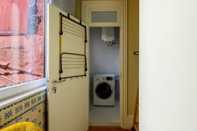 a washer and dryer in a bathroom with a door at Photography Apartments in Porto