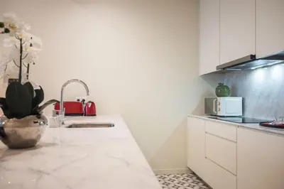 a kitchen with white cabinets and a counter top at Luxury Style 10 with AC Downtown Porto near Metro in Porto