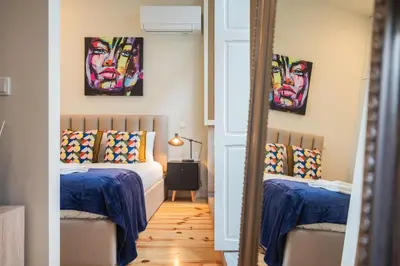 a bedroom with two beds and paintings on the walls at Luxury Style 10 with AC Downtown Porto near Metro in Porto