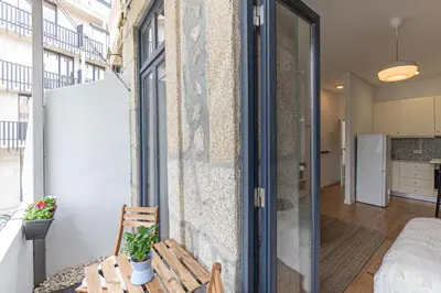 a small apartment with a balcony with a table at Studio Apartment Torrinha in Porto