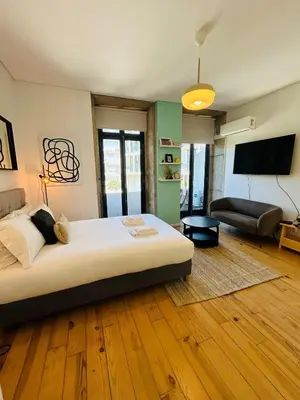 a bedroom with a bed and a living room at Studio Apartment Torrinha in Porto