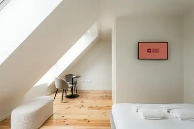 a white bedroom with a bed and a staircase at GuestReady - A fantastic home in Porto in Porto