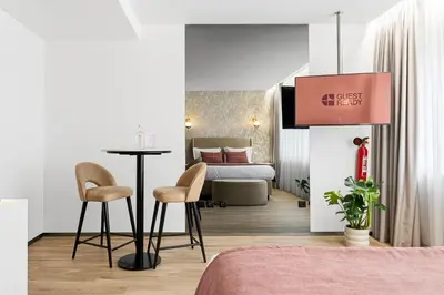 a hotel room with a bed and a table and chairs at GuestReady - Alma Invicta in Porto