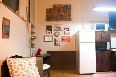 a kitchen with a refrigerator and a chair in a room at A Oficina do Costa in Vila Nova de Gaia