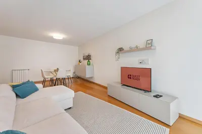 a living room with a white couch and a television at GuestReady - Modern apartment in Boavista in Porto