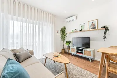 a living room with a couch and a tv at The Campinho Terrace, Central Balcony Stay in Porto