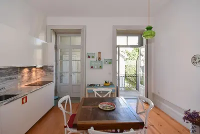 a kitchen with a wooden table and a dining room at Art & City in Porto