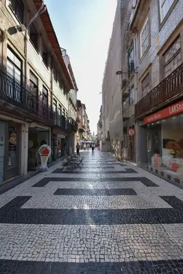 a cobblestone street in a city with buildings at Art & City in Porto