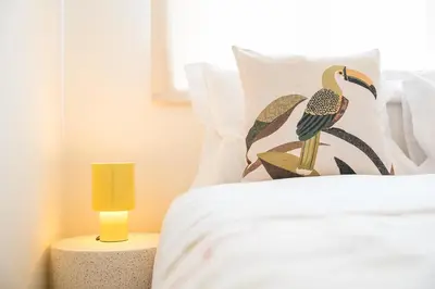 a bedroom with a bed with a bird pillow and a yellow lamp at GuestReady - Porto stay with outdoor charm in Porto
