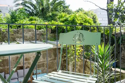 a green chair sitting next to a table on a balcony at GuestReady - Urban paradise in Porto in Porto