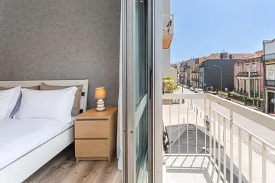 a bedroom with a bed and a balcony with a view at GuestReady - Lovely family home in Boavista in Porto