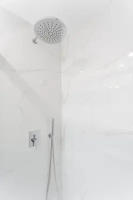 a white bathroom with a shower and a ceiling at GuestReady - Lovely family home in Boavista in Porto