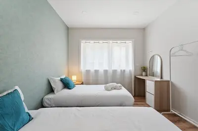 two beds in a small bedroom with a window at GuestReady - Lovely family home in Boavista in Porto