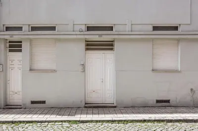 a white building with two doors and a sidewalk at GuestReady - Central & spacious apartment in Porto in Porto