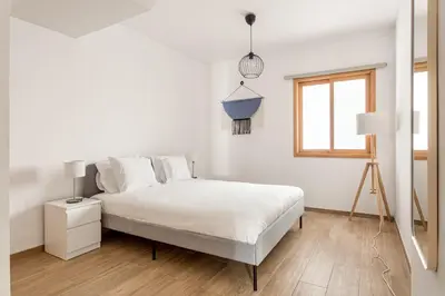 a white bedroom with a bed and a window at GuestReady - Central & spacious apartment in Porto in Porto