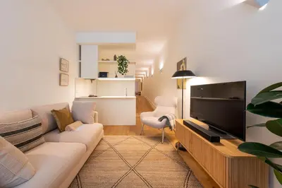 a living room with a couch and a tv at Almada 559 - Almeida Garrett Nook by Lisbeyond in Porto