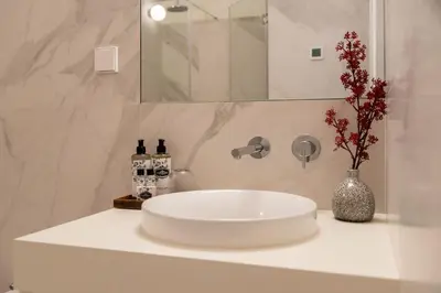 a bathroom with a white sink and a vase with flowers at Almada 559 - Almeida Garrett Nook by Lisbeyond in Porto