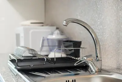 a kitchen sink with a dish drying rack on it at GuestReady - Sunny patio paradise in Porto in Porto