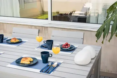a table with two plates of food and glasses of orange juice at GuestReady - Sunny patio paradise in Porto in Porto