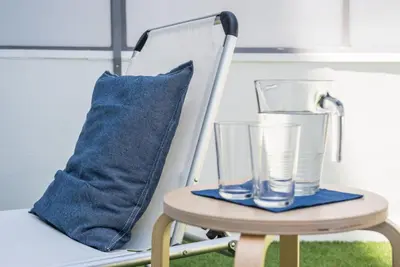 a chair with a pillow and a glass on it at GuestReady - Sunny patio paradise in Porto in Porto