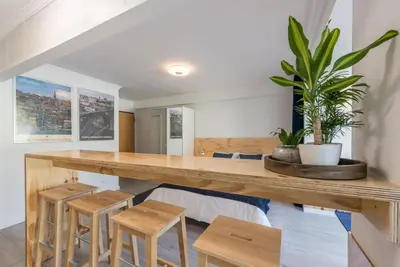 a dining room with a wooden table and stools at GuestReady - Sunny patio paradise in Porto in Porto