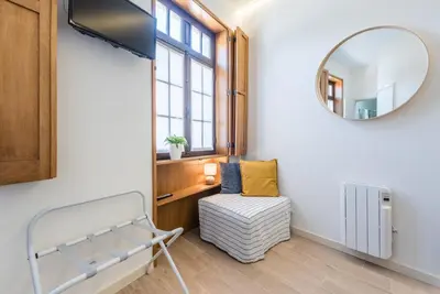 a dressing room with a mirror and a chair at GuestReady - Timber-framed luxe stay in Porto