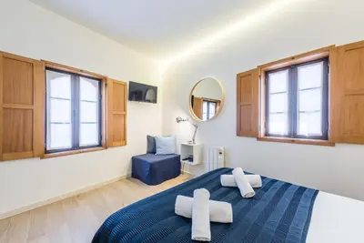 a bedroom with a bed and a mirror at GuestReady - Timber-framed luxe stay in Porto