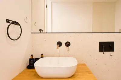 a bathroom with a white sink on a wooden counter at Porto- Boavista Casa Da Música - Art Gallery Apartment II in Porto