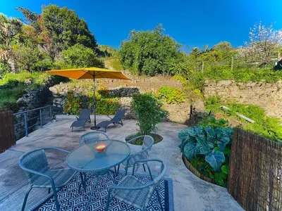 a patio with a table and chairs and an umbrella at Casa dos Moinhos - Country House in Porto City in Porto